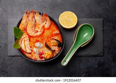 Traditional Thai soup Tom Yum kung with seafood, coconut milk and chili pepper. Top view flat lay - Shutterstock ID 1912016437