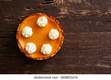 Traditional thanksgiving food on wooden table. Orange delicious homemade pumpkin pie with crust and decorative topping. Top view, close up, copy space, background. - Powered by Shutterstock