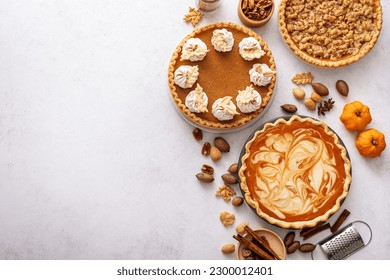 Traditional Thanksgiving pies with pumpkin pie in the middle overhead view on white