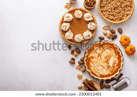Traditional Thanksgiving pies with pumpkin pie in the middle overhead view on white