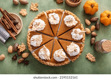 Traditional Thanksgiving Pumpkin Pie Cut Into Slices Overhead View On A Green Surface