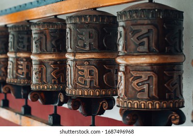 Traditional Tibetan Buddhist prayer wheels with mantras. Translation on prayer wheels text: Mani means "jewel" or "bead", Padme is the "lotus flower", and Hum represents the spirit of enlightenment.