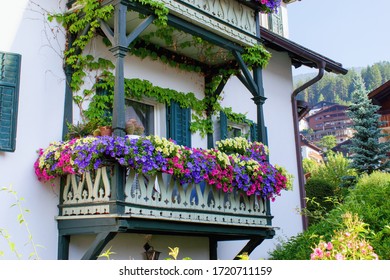 Traditional tirol house balcony decorated with varieties of petunia and surfinia flowers, Dolomites Italy, European Alps