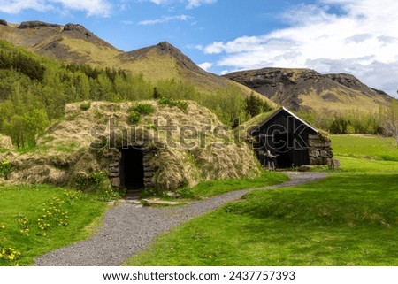 Traditional turf house village in Skogar Open Air Museum, black wooden facade and stone residential buildings with roofs covered with turf and moss, Iceland.