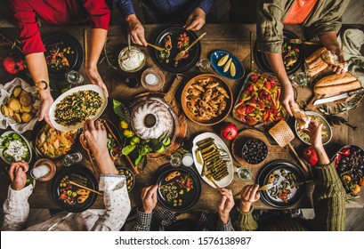 Traditionelles türkisches Fest-Dinner. Flat-lay von Menschen, die am Tisch mit türkischen Salaten, gekochtes Gemüse, Meze Vorspeisen, Gebäck und Raki trinken, Draufsicht. Nahostküche