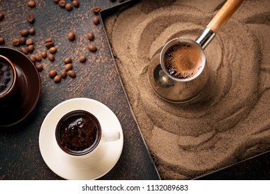 Traditional turkish coffee in cezve prepared on hot sand. Selective focus