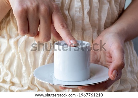 Traditional Turkish coffee fortune telling. The woman is checking the grounds remaining in cup and whether the coffee is cold to start reading fortune telling 
