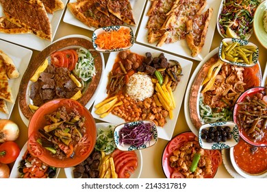 Traditional Turkish cuisine. Pizza, pita, pidesi, sucuk, hummus, kebab. Many dishes on the table. Serving dishes in restaurant. Background image. Top view, flat lay - Shutterstock ID 2143317819