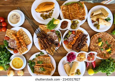 Traditional Turkish cuisine. Pizza, pita, pidesi, sucuk, hummus, kebab. Many dishes on the table. Serving dishes in restaurant. Background image. Top view, flat lay