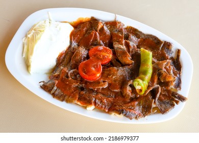 Traditional turkish iskender kebab in copper plate with yogurt, grilled tomatoes and fresh vegetables. - Shutterstock ID 2186979377