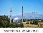 Traditional Turkish mosque on the background of Mount Erciyes. Religious building