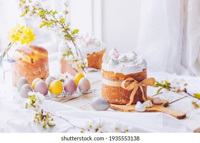 Traditional ukrainian easter cake with white swiss meringue. New cruffin cake trend 2024. Spring cherry blossom and colorful painted eggs. Person decorates cake with hand. Free copy space. - Powered by Shutterstock