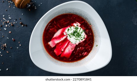 Traditional ukrainian or russian beetroot soup (borscht) with greens and sour cream. Borscht soup made from beets, potatoes, cabbage, onions and spices with sour cream and greens. Top view. - Powered by Shutterstock