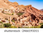 Traditional village with clay houses in mountain landscape full of palm trees in Dades valley, Morocco, North Africa