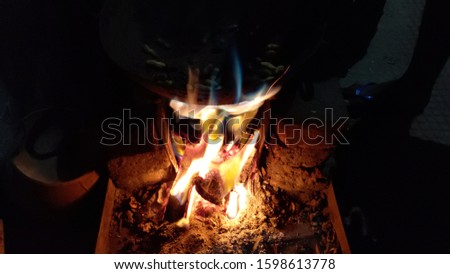 Traditional way of making food on open fire in old kitchen in a village hotel, Rajasthan India. Rural kitchen using bio wood fuel for cooking.