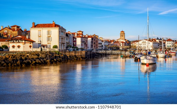 Traditional white houses in St\
Jean de Luz Old Town and port, Basque country, France, in sunset\
light