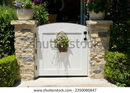 Traditional white wood garden gate with decorative flower basket