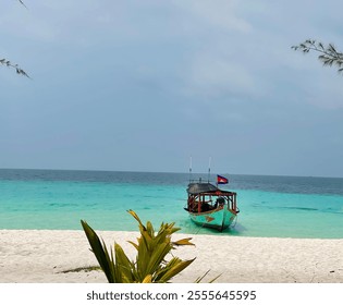 A traditional wooden boat docked on a tropical beach with clear turquoise water. - Powered by Shutterstock