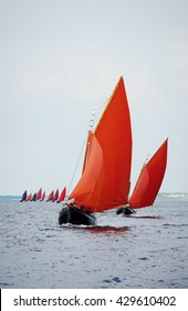 Traditional wooden boat Galway Hooker, with red sail, compete in regatta. Ireland.