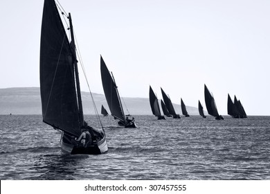 Traditional wooden boats Galway Hooker, with red sail, compete in regatta. Ireland.
