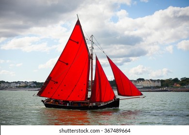 Traditional wooden boats Galway Hooker, with red sail, compete in regatta. Ireland.