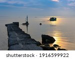 Traditional wooden fishing boat leaving a marina in Thessaloniki, Greece at sunset