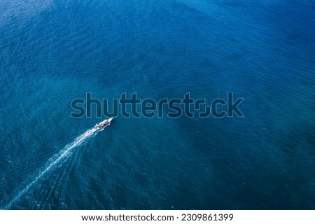 Traditional wooden fishing boat sailing in tropical deep blue sea on summer at sunny day