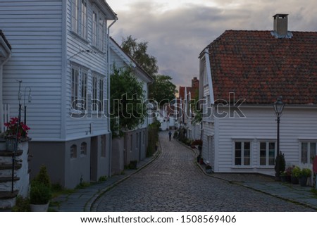 Traditional wooden houses in Gamle Stavanger. Gamle Stavanger is a historic area of the city of Stavanger in Rogaland, Norway. Beautiful summer sunset with coloured sky. July 2019