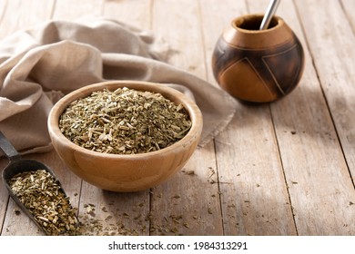 Traditional yerba mate tea in bowl on wooden table. Copy space