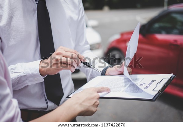 Traffic Accident
and insurance concept, Insurance agent working on report form with
car accident claim
process.