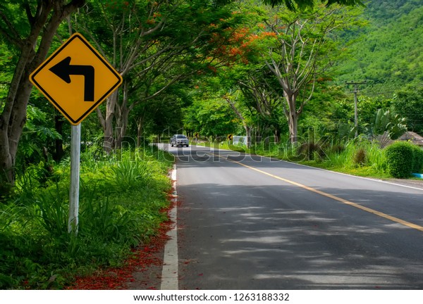 Traffic alerts downhill slope. Reduce speed and
use a lower gear.arrow traffic sign with blue sky.warning sign on
the street.