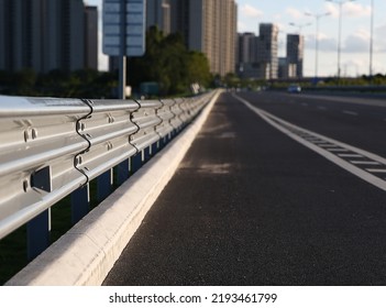 Traffic barrier on bridge highway road. Median crash barriers for protect vehicles from accident.  Industrial city background.