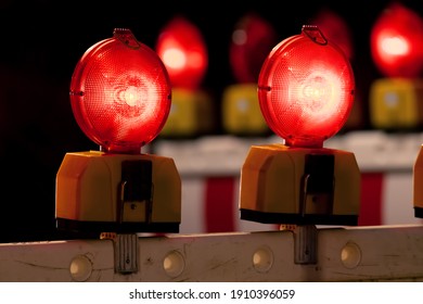 Traffic barring with red battery flash lights indicating road closure, “no entry“ or “do not pass“ at construction sites, accidents or blocked roads. Symbol for shut down or lockdown in the pandemic.
