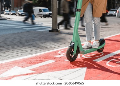 Traffic, City Transport And People Concept - Woman Riding Electric Scooter Along Red Bike Lane With Signs Of Bicycles And Two Way Arrows On Street