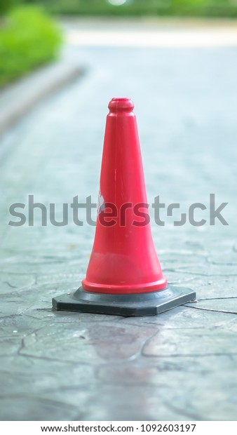 Traffic cone on road. Red traffic cone\
standing outside. Traffic cone at parking\
area