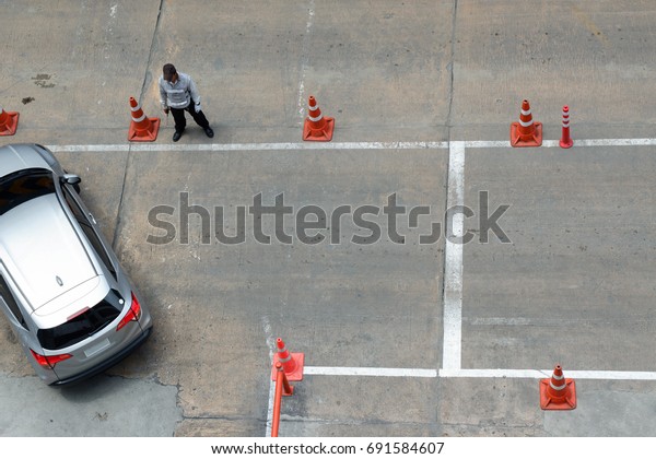 Traffic cone on the road with security staff care\
about traffic