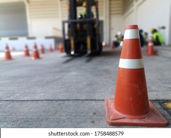 Traffic Cone Put On Cement Floor With Blurred Background Of Fork Lift In Driver Training Area, Outdoor Forklift Training Class In Factory 