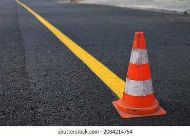 Traffic Cone And Temporary Yellow Line On To Mark Road Works Or Temporary Obstruction. Selective Focus.