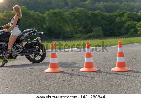 Traffic cones on the moto track. Driving courses or driving licence training. Focus on the orange traffic cones