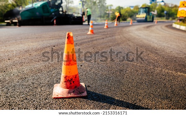 Traffic cones on road. A large layer of\
fresh hot asphalt. Road\
construction.