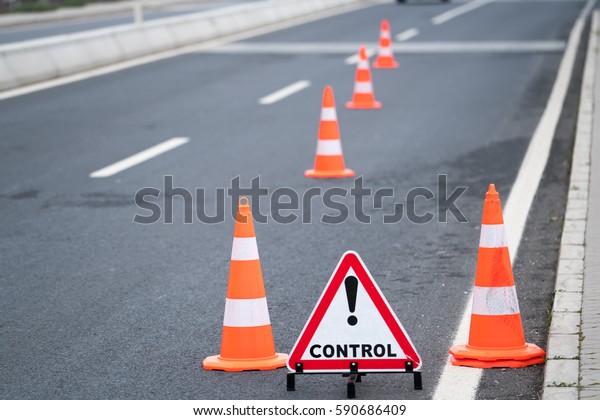 Traffic control cones at side street.Police\
stops cars for the control or\
accident.