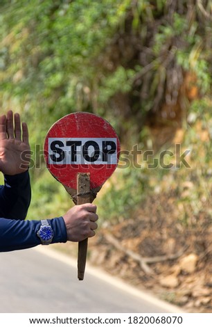 Traffic controller on the street (hand with a stop sign). Specific traffic controller's baton in Sri Lanka
