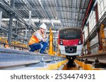 Traffic controller or railway technician engineer worker woman hold tablet with green screen and checking controls system for security functions in maintenance plant of sky train. electric train.