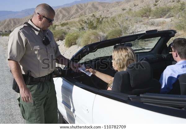 Traffic cop checking woman\'s\
license