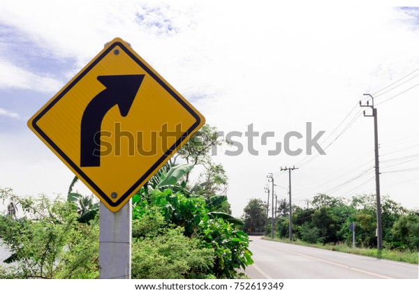 The traffic curve of arrow in yellow sign with\
sky background