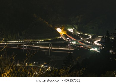 Traffic Cuts Through Japanese Countryside Highway Clover Leaf And Tunnel Near Mount Takao At Night