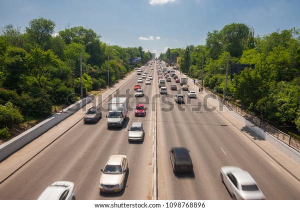 Traffic\
flow on highway during rush hour on sunny hot day. Highway is\
multi-lane highway and major intracity\
freeway