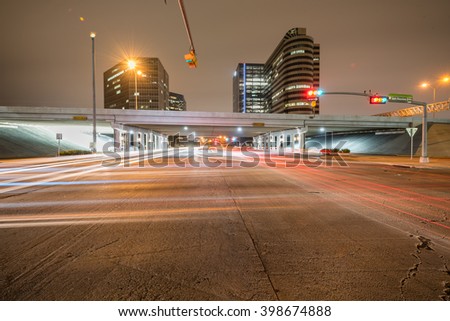 Traffic at the intersection of Sam Houston Parkway express with light trails from vehicle headlight motion. Transportation urban and motion concept. Houston, Texas.