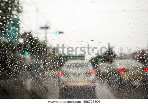 Traffic jam during the heavy rain with rain drops\
on car glass.