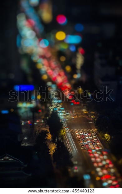 Traffic jam at night, expressed in an artistic way
using tilt-shift telephoto lens with a high angle view, showing
out-of-focus bokehs of lights from cars and neon lights. Chengdu,
Sichuan, China.
